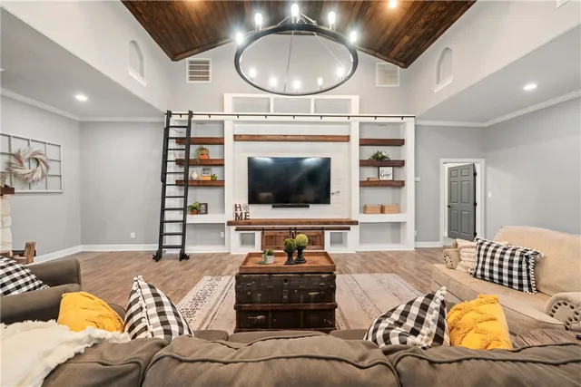 a living room with furniture a flat screen tv and kitchen view