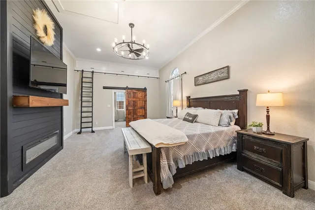 a spacious bedroom with a bed and a chandelier