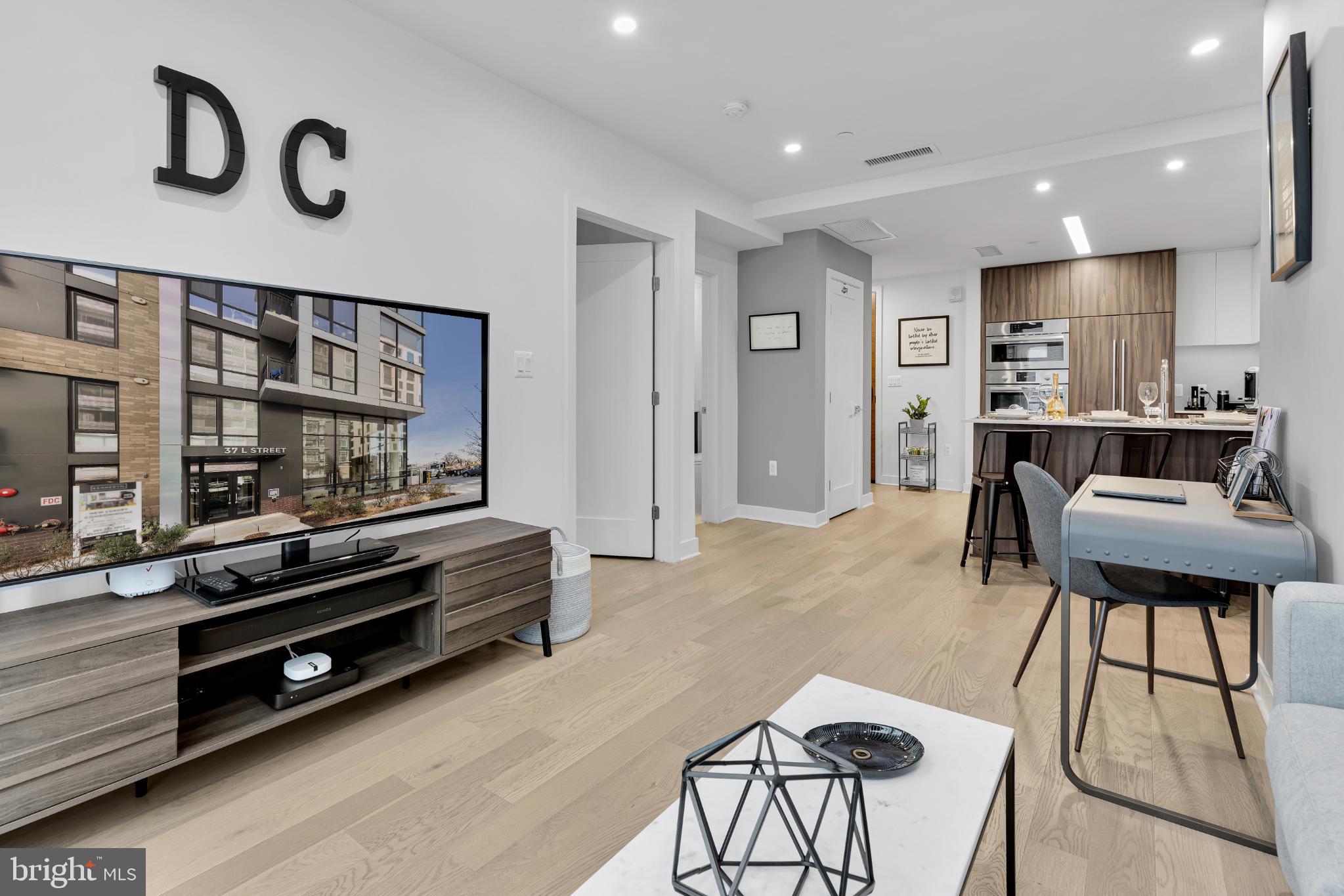 37 L Street Southeast, Unit 308 Washington, DC 20003 - Photo 19 of 43 a living room with furniture a flat screen tv and kitchen view