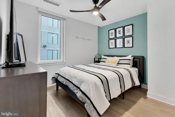 a bedroom with a bed wall painting and a window