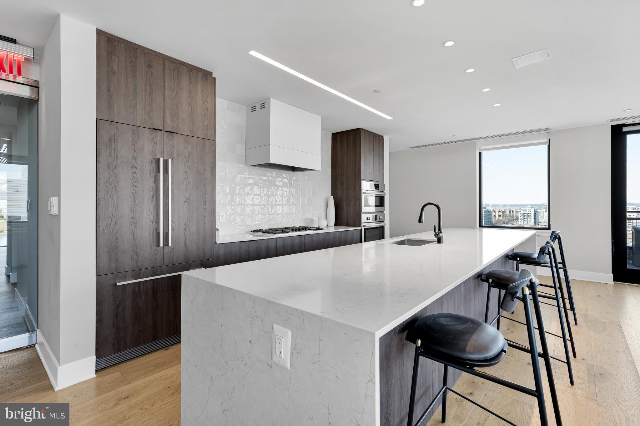 37 L Street Southeast, Unit 308 Washington, DC 20003 - Photo 24 of 43 a kitchen with stainless steel appliances a refrigerator and a table