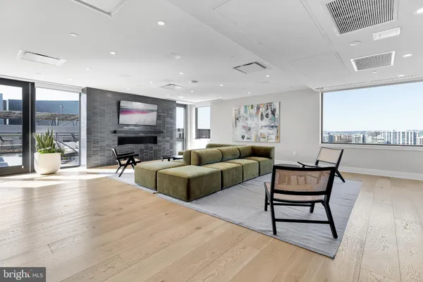 a living room with furniture and a dining table with wooden floor
