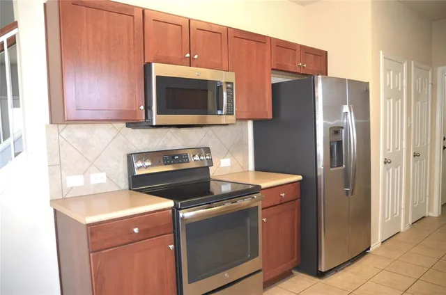 a kitchen with stainless steel appliances granite countertop a refrigerator stove and microwave