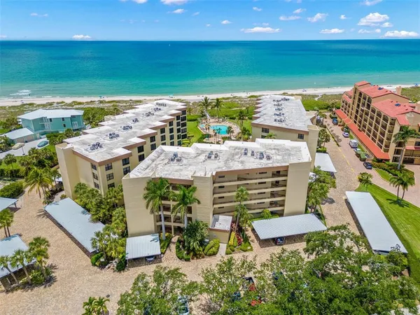 an aerial view of residential houses with outdoor space and ocean view