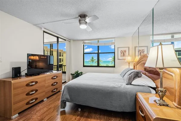 a bedroom with a bed and a flat tv screen on dresser