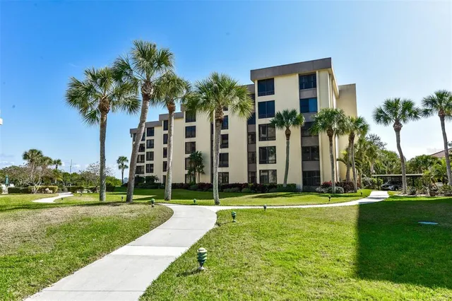 a view of a apartment with a big yard and palm trees