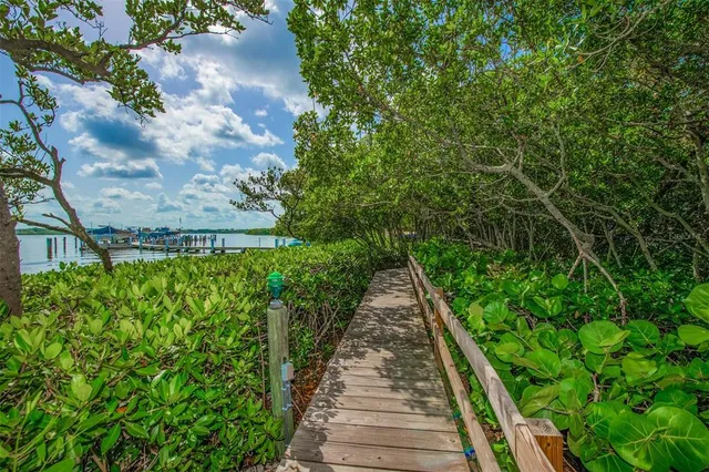 a group of people sitting under an umbrella in front of retail shop