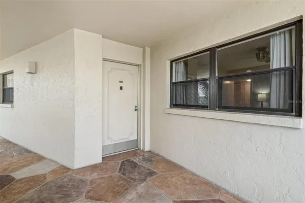 a view of an empty room with closet and windows