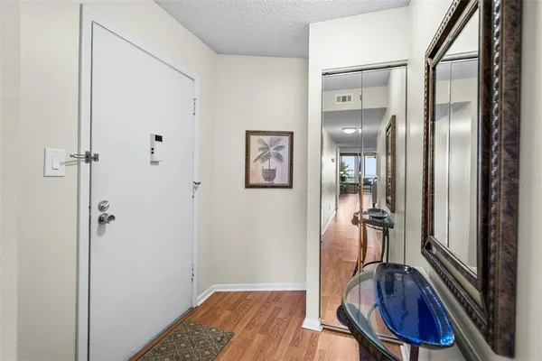 a view of a hallway with wooden floor and furniture