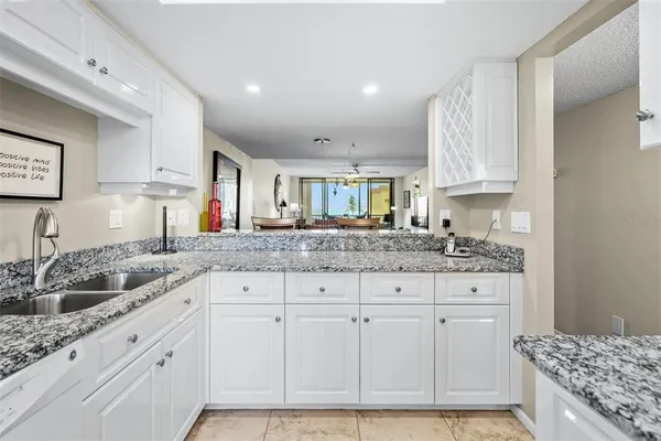 a kitchen with granite countertop a sink and cabinets