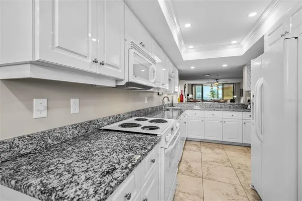 a kitchen with white cabinets and appliances