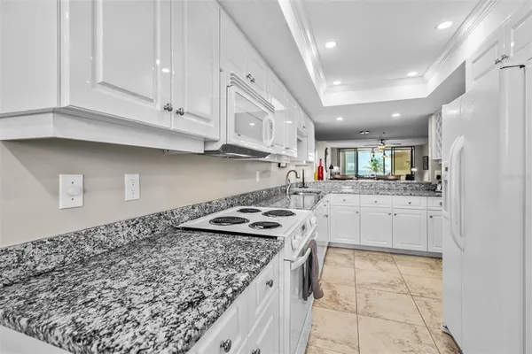 a kitchen with white cabinets and appliances