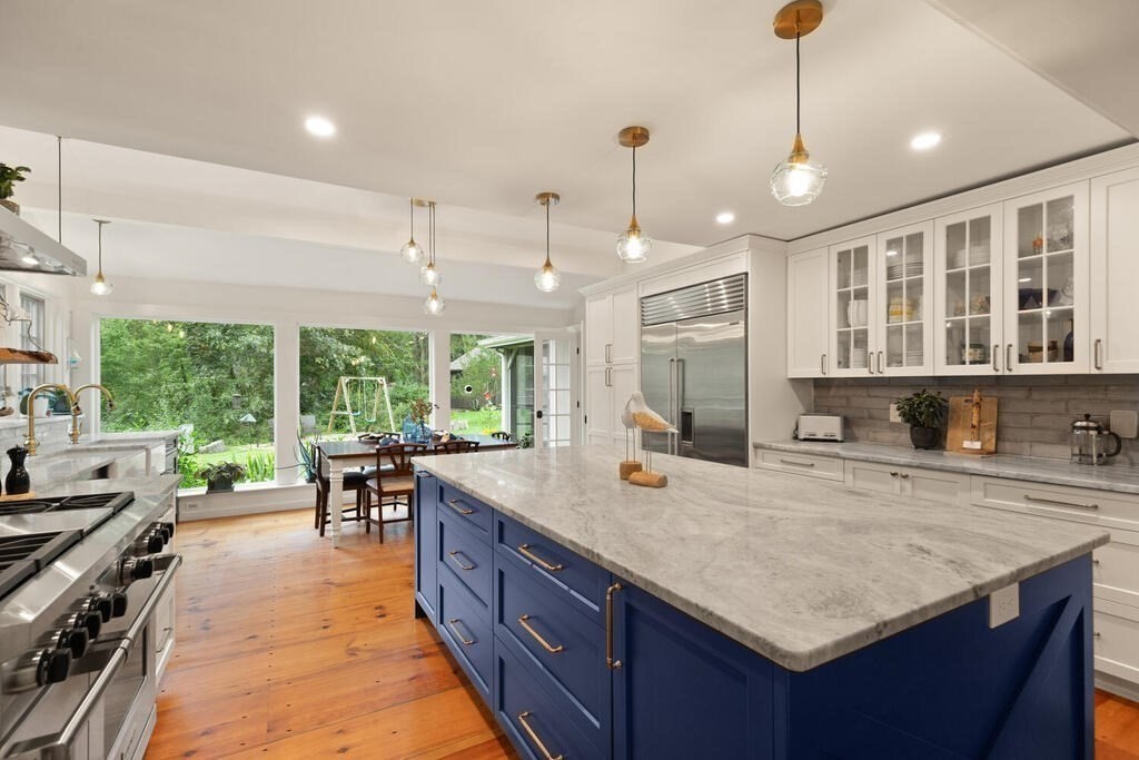 6 Lawrence Road Boxford, MA 01921 - Photo 4 of 42 a kitchen with a stove a kitchen island a dining table and chairs with wooden floor