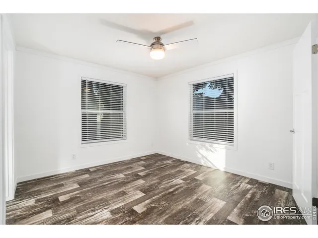 an empty room with windows and ceiling fan
