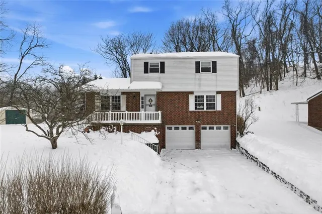 a view of a house with a yard covered in snow