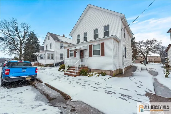 a view of a white house with a snow on the road
