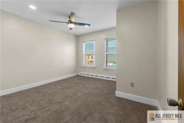 an empty room with window and ceiling fan
