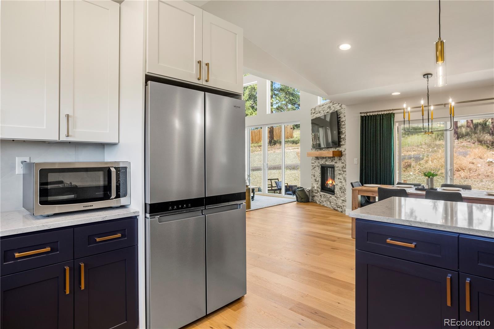 518 Conifer Drive Bailey, CO 80421 - Photo 16 of 50 a kitchen with stainless steel appliances granite countertop a refrigerator a stove and a sink with wooden floor