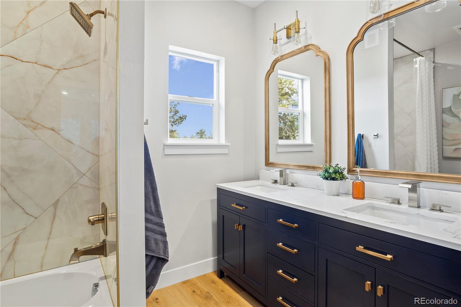 518 Conifer Drive Bailey, CO 80421 - Photo 39 of 50 a bathroom with a granite countertop sink a mirror and a bathtub next to a window