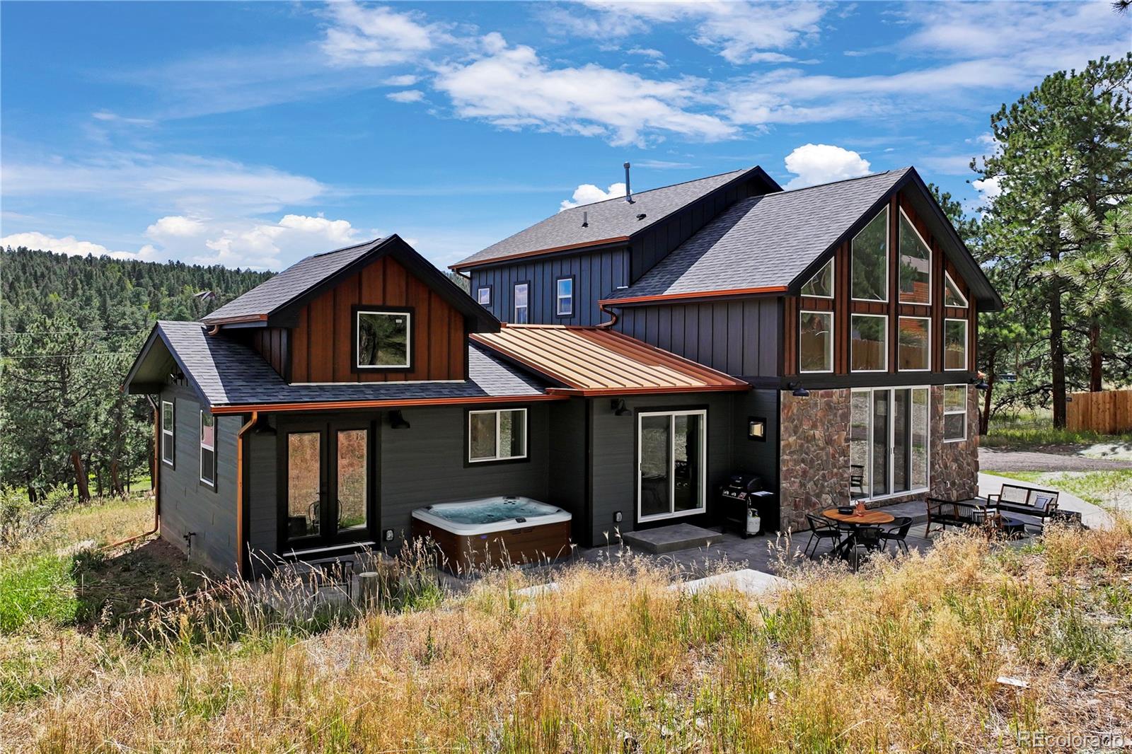 518 Conifer Drive Bailey, CO 80421 - Photo 43 of 50 a backyard of a house with wooden fence and a lawn chairs