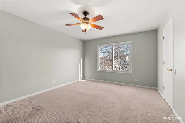 a view of a big room with windows and chandelier fan