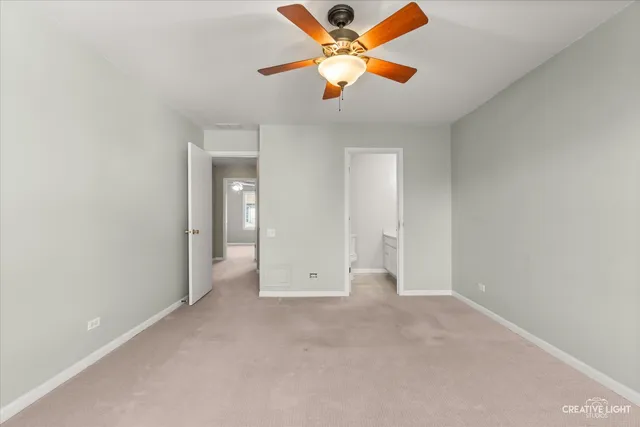 an empty room with closet and fan