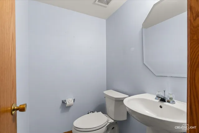 a white toilet sitting next to a bathroom sink