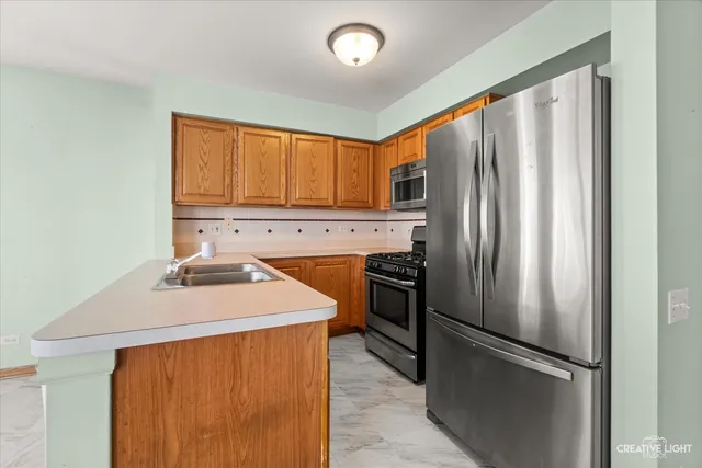 a kitchen with stainless steel appliances granite countertop a refrigerator a sink a stove and island