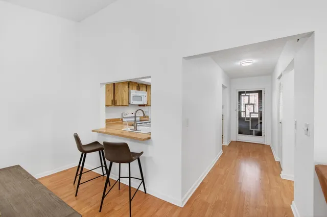 a living room with furniture kitchen view and large windows