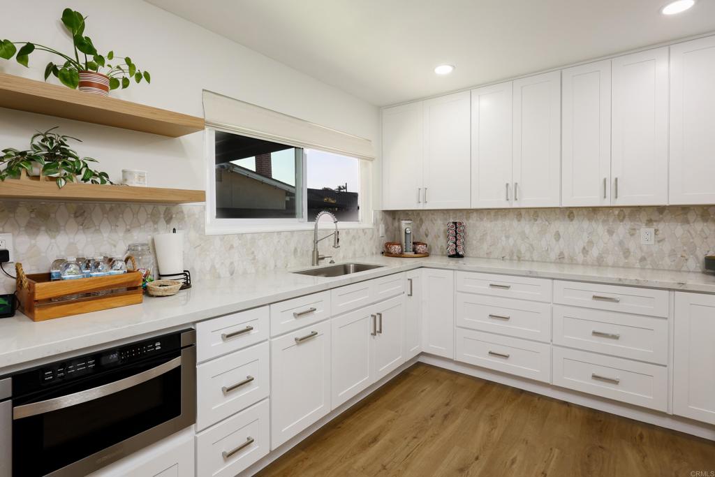 a kitchen with granite countertop white cabinets and white appliances