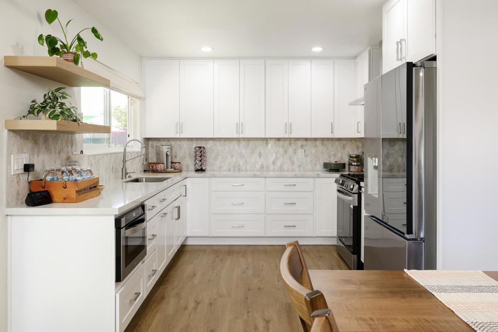 1024 Ransom Street San Diego, CA 92154 - Photo 4 of 41 a kitchen with a refrigerator a sink dishwasher and white cabinets with wooden floor