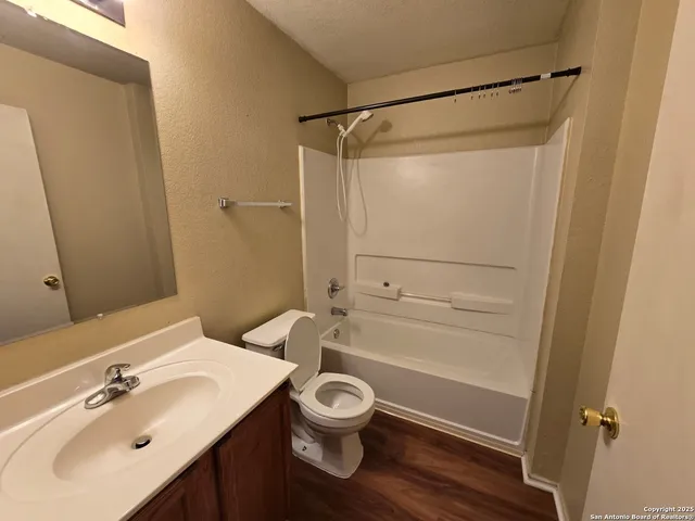 a bathroom with a shower sink vanity and toilet