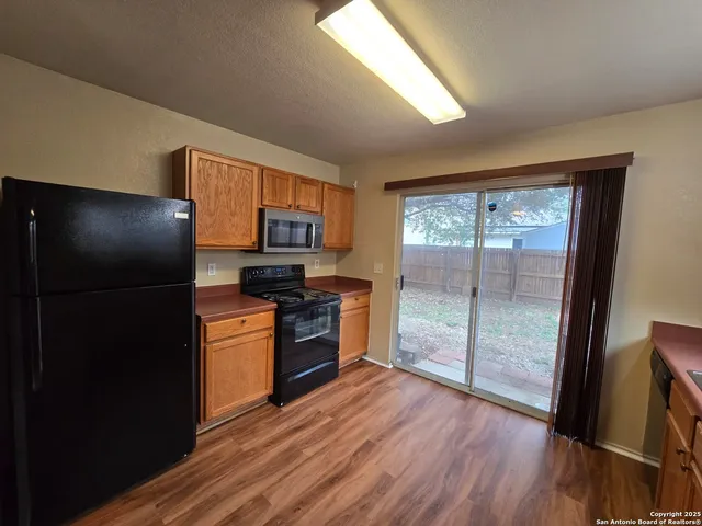 a kitchen with stainless steel appliances granite countertop a refrigerator and a sink