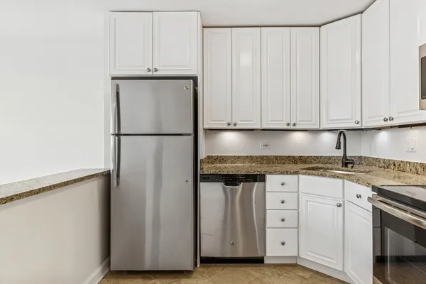 a kitchen with granite countertop cabinets and refrigerator