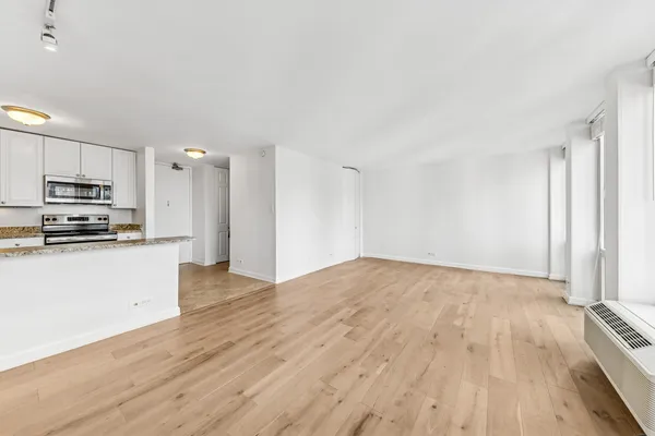 a view of kitchen with wooden floor and electronic appliances