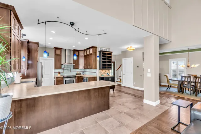 a spacious bedroom with a bed a dresser and wooden floor