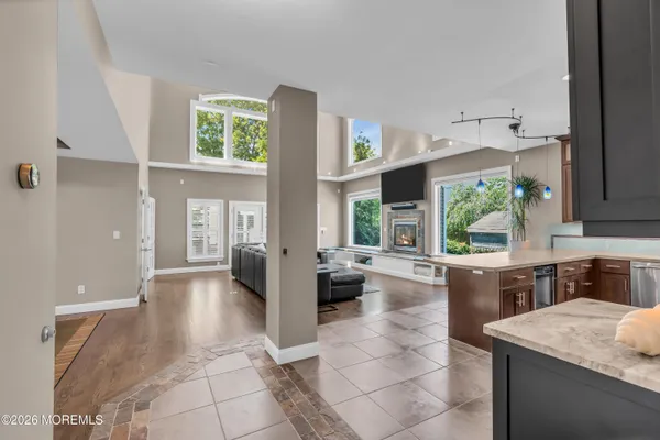 a living room with stainless steel appliances granite countertop furniture wooden floor and a large window