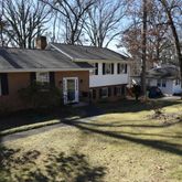 a view of a white house with a yard covered with snow