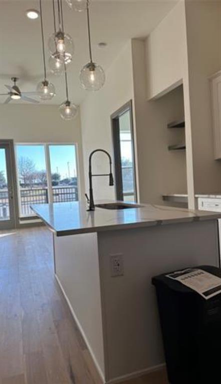 2700 Old Denton Road, Unit 1043 Carrollton, TX 75007 - Photo 2 of 14 Kitchen featuring decorative light fixtures, light wood finished floors, healthy amount of natural light, a kitchen island with sink, and recessed lighting