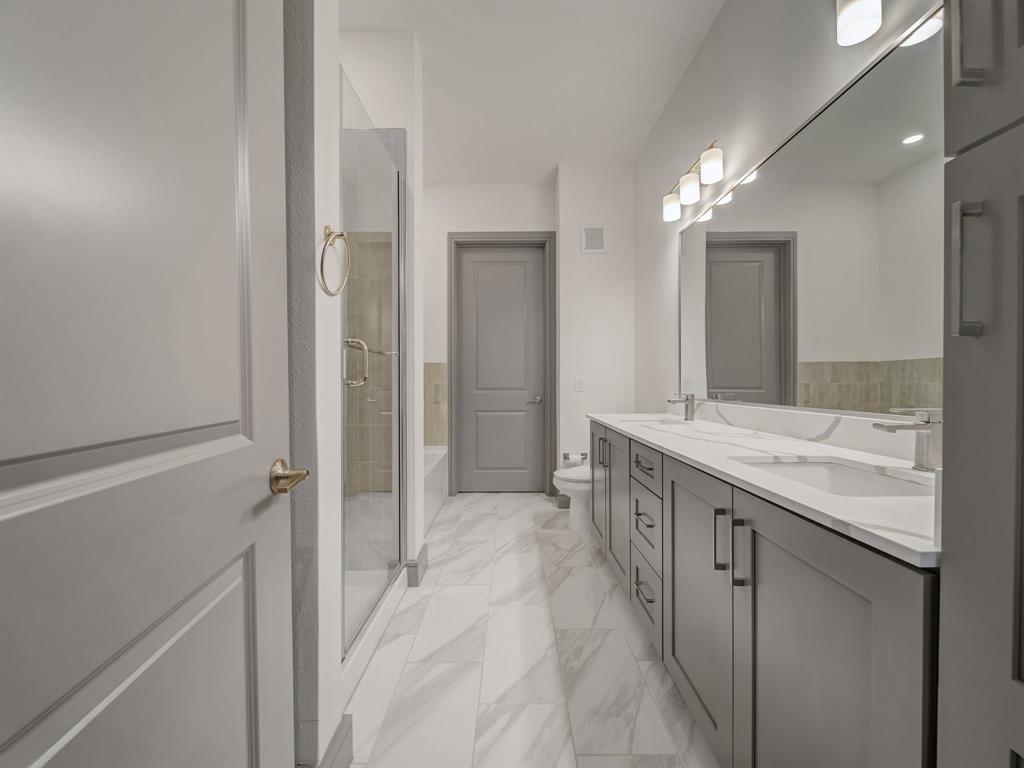 2700 Old Denton Road, Unit 1043 Carrollton, TX 75007 - Photo 9 of 14 Bathroom with double vanity, a shower stall, light marble finish floors, and a tub to relax in