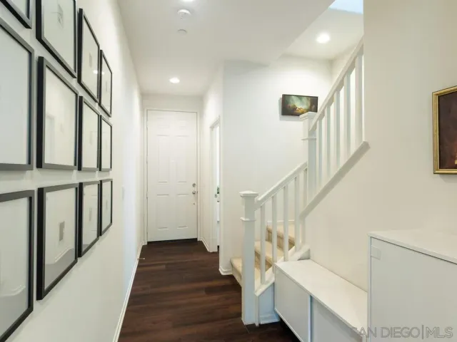 a view of staircase with lots of frames on wall and wooden floor