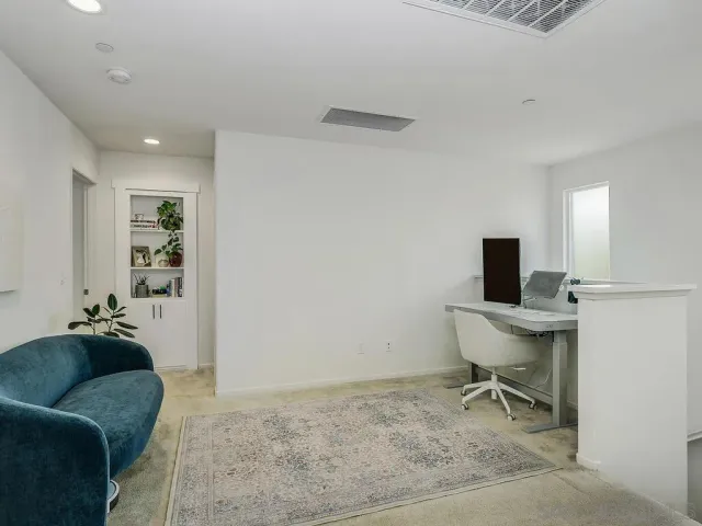 a view of a workspace with furniture and a window