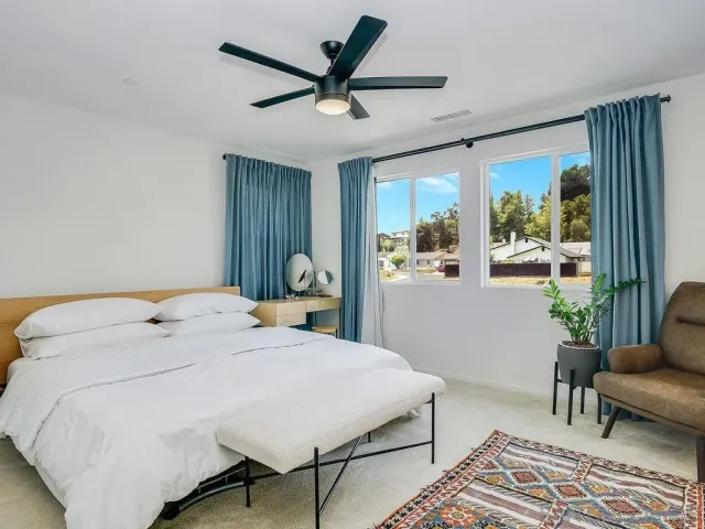 a bedroom with a bed a couch and a window