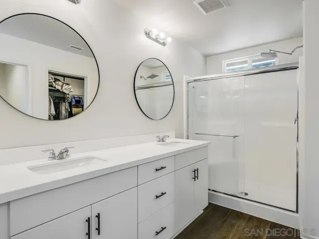 a bathroom with a double vanity sink and a mirror