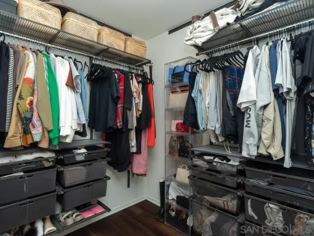 a view of walk in closet with clothes and shoes