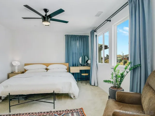 a bedroom with a bed a couch and a potted plant