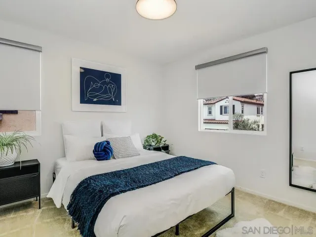 a bedroom with a bed and a painting on the wall