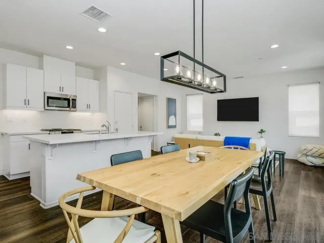 a kitchen with stainless steel appliances a table chairs and a chandelier