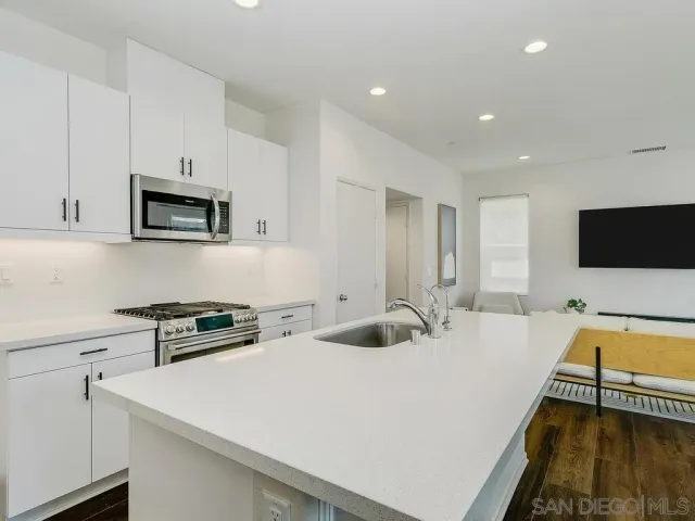 a kitchen with a sink a stove and cabinets