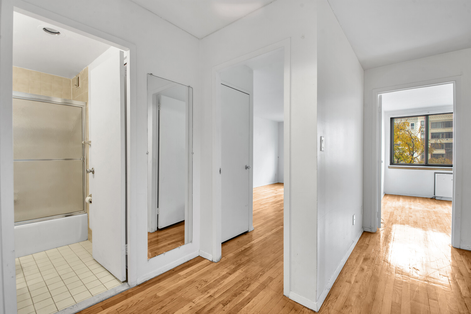 414 West 54th Street, Unit 5C Manhattan, NY 10019 - Photo 5 of 8 a view of a hallway with wooden floor and a living room